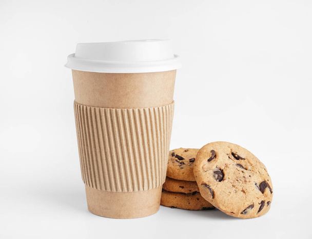 Бумажная чашка и вкусное печенье на белом фоне - Фото, изображение