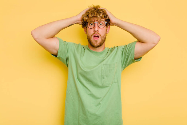 Young caucasian man isolated on yellow background surprised and shocked. - Photo, Image