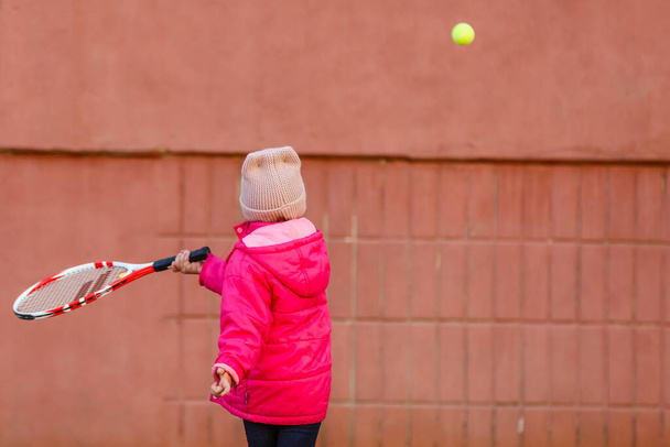 Pequeña linda chica jugando al tenis al aire libre - Foto, Imagen
