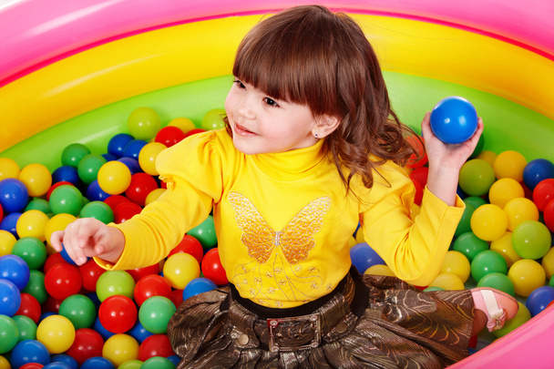 Happy child in group colourful ball. - Zdjęcie, obraz