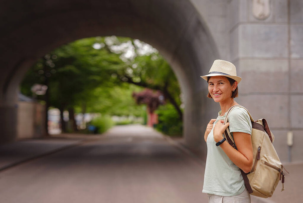 utazás nyárra Európába fiatal ázsiai nő. Egy nő, aki Svájcban vakációzik, Basel. A hölgy a Rajna folyó partján sétál. - Fotó, kép