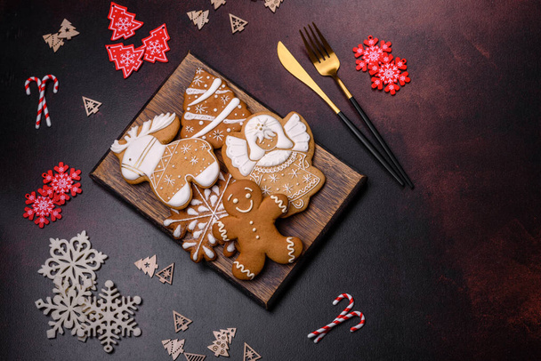 Elementos de decoración navideña, así como pan de jengibre sobre un fondo de hormigón marrón. Preparación de una mesa festiva - Foto, Imagen