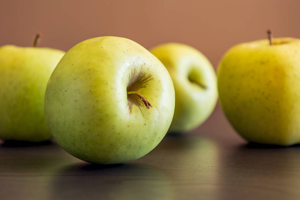Куча зеленых яблок за кухонным столом. - Фото, изображение
