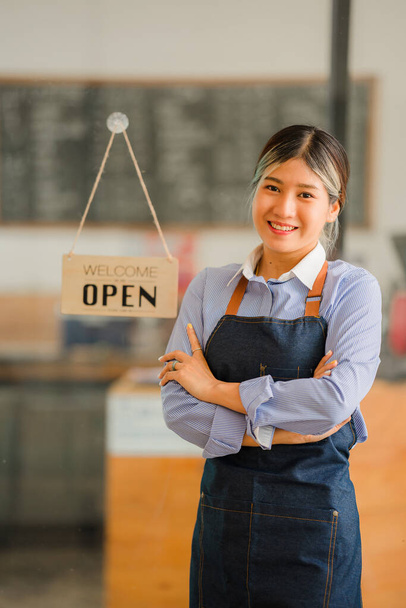 Asian women set up a sign to open a shop to welcome customers at a coffee shop. small business owner and startups and coffee shops food and drink concept - Zdjęcie, obraz