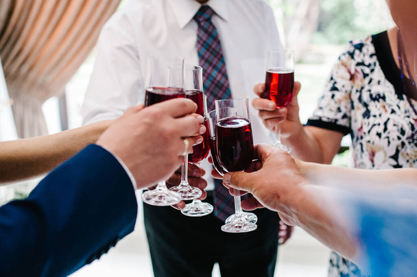 Cheers! People celebrate and raise glasses of wine for toast. Group of man and woman cheering with champagne. - Foto, Imagen
