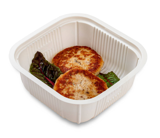  Fried chicken cutlets. In a plastic container. Food to go. On a light background. - Фото, зображення