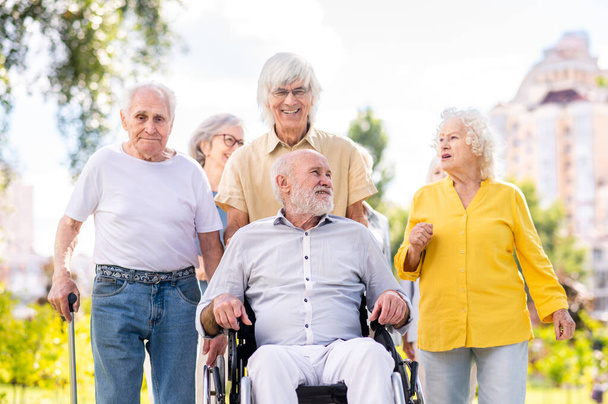 Group of happy elderly people bonding outdoors at the park - Old people in the age of 60, 70, 80 having fun and spending time together, concepts about elderly, seniority and wellness aging - Foto, afbeelding