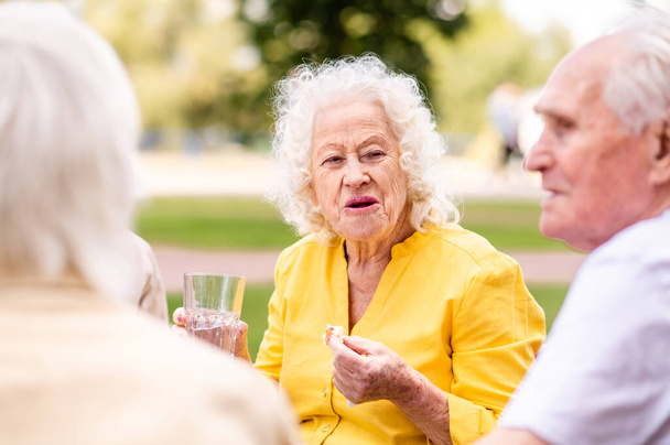 Group of happy elderly people bonding outdoors at the bar cafeteria - Old people in the age of 60, 70, 80 having fun and spending time together, concepts about elderly, seniority and wellness aging - Zdjęcie, obraz