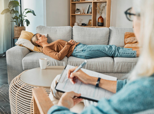 Relax, psychology and therapist with woman patient struggling with depression resting on sofa. Professional psychologist analysis notes for consultation to help emotional mental health client - Foto, immagini