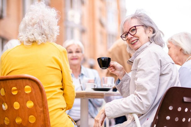 Group of happy elderly people bonding outdoors at the bar cafeteria - Old people in the age of 60, 70, 80 having fun and spending time together, concepts about elderly, seniority and wellness aging - Foto, Imagem
