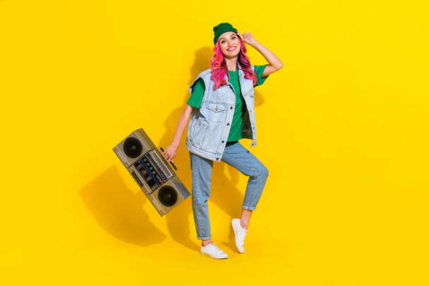 Full length photo of funny positive lady wear jeans waistcoat holding boombox smiling isolated yellow color background. - Fotografie, Obrázek