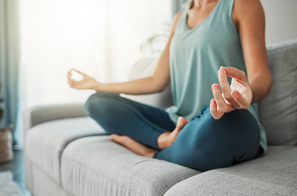 Meditation, yoga peace and hands of woman working on spiritual wellness on living room sofa in her house. Calm person with lotus zen pose for faith, mind health in the morning on the couch. - Фото, зображення