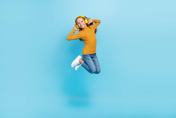 Full length portrait of cheerful crazy schoolchild jumping have good mood isolated on blue color background. - Foto, Imagen