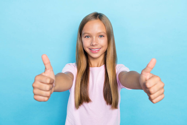 Photo of good mood funny school girl with straight hairdo dressed pink t-shirt showing thumbs up isolated on blue color background. - Valokuva, kuva