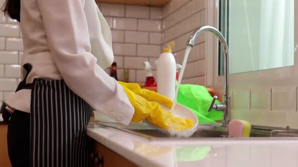 Женщина, работающая в офисе в костюме, моет посуду дома после работы. Концепция работающих женщин. домашняя работа женщина - Кадры, видео