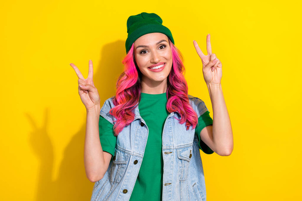 Photo of satisfied glad nice lady dressed fashionable green denim outfit demonstrate arms hi v-sign isolated on yellow color background. - Foto, Bild