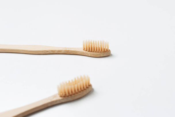 Close-up van twee bamboe tandenborstels geïsoleerd op witte achtergrond. Gezondheidszorgconcept. - Foto, afbeelding
