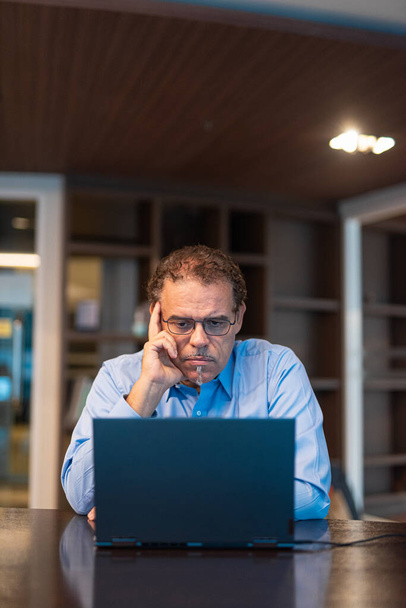 Ritratto di uomo d'affari che utilizza il computer portatile in ufficio colpo verticale - Foto, immagini
