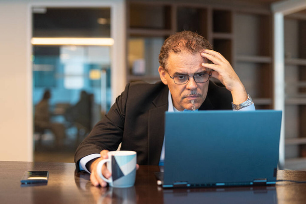 Retrato de hombre de negocios utilizando ordenador portátil en la oficina plano horizontal - Foto, imagen