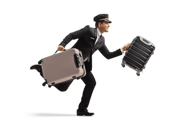Full length profile shot of a bellboy running and carrying suitcases isolated on white background - Foto, Imagem