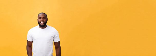 Portrait of a modern young black man smiling standing isolated yellow background. - Photo, Image