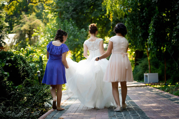 bride in white dress walks with bridesmaids - Photo, Image