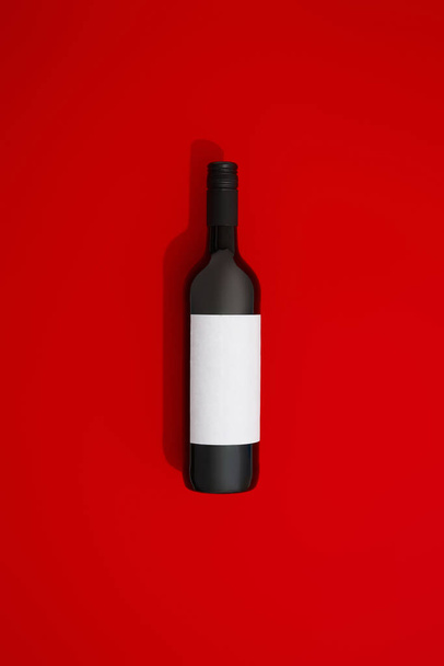 Wine bottle with blank label. Red wine on colorful background with copy space. Product branding mock up. - Foto, Bild