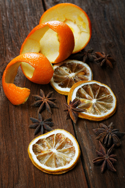 Dried peel of an orange and spice on a table - Фото, изображение
