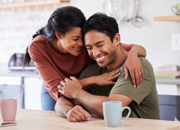 Couple, love and laugh with a man and woman hugging, laughing or having fun in the kitchen of their home together. Happy, smile and humor with a married male and female embracing in their house. - Foto, Imagem