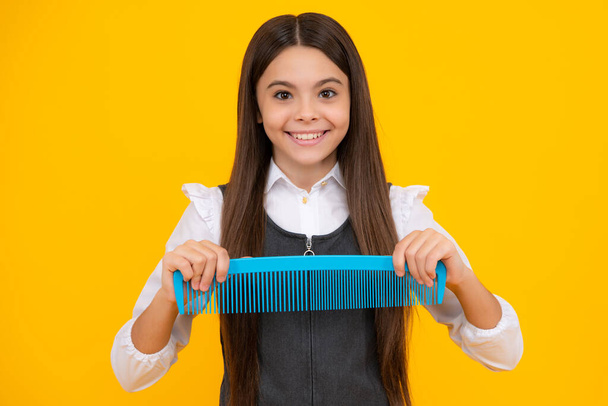 Dospívající dívka dívka s kartáč česání vlasy. Dívka se stará o vlasy a účes. Kadeřník vlasy solon pro teenager - Fotografie, Obrázek