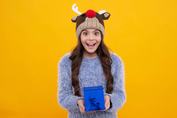 Happy girl face, positive and smiling emotions. Funny kid girl in winter wear holding gift boxes celebrating happy New Year or Christmas. Winter holiday - Photo, Image