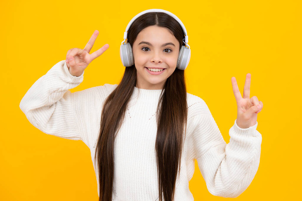 Funny kid girl 12, 13, 14 years old listen music with headphones. Teenage girl with headphones listening songs on headset earphone - Zdjęcie, obraz