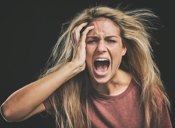Face, mental health and screaming woman headache, anxiety or stress. Psychology, bipolar or crazy, insane or depressed schizophrenia female, shouting or hearing voices alone on dark studio background. - Fotó, kép