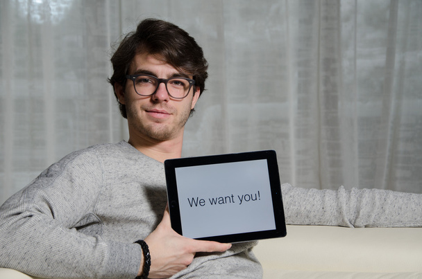 Jovem com mensagem queremos-te no tablet
 - Foto, Imagem