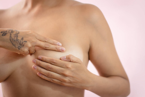 Nahá latinská žena provádějící sebekontrolu prsu, aby odhalila abnormality jako prevenci rakoviny prsu. Kvalitní fotografie - Fotografie, Obrázek