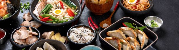 Traditional Asian food. Various of asian meals on dark background. Assorted dishes of traditional cuisine. Top view, panorama, banner - Фото, изображение