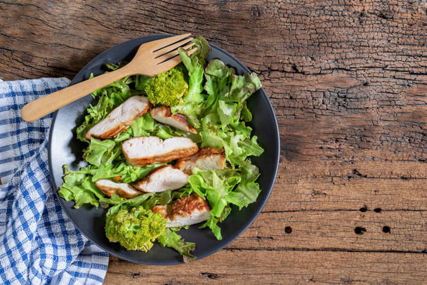 Chicken salad in bowl on wood background close up, top view, healthy food concept. - Valokuva, kuva