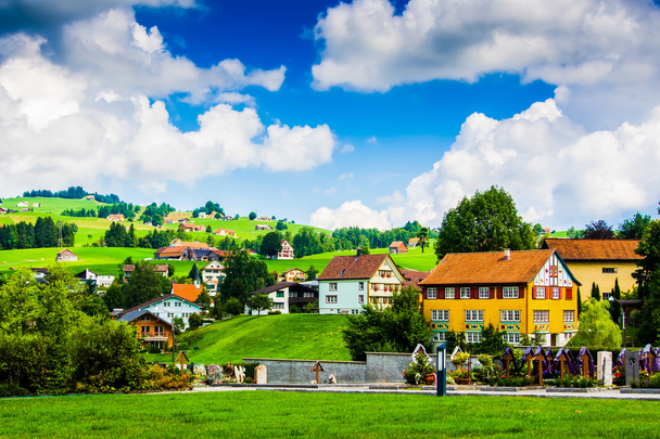 Casas em uma pequena cidade suíça com nuvens e céu azul no backgr
 - Foto, Imagem