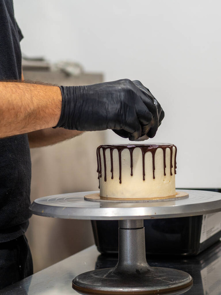 operaio irriconoscibile preparare una torta di cioccolato gocciolante dolce e bacche - Foto, immagini