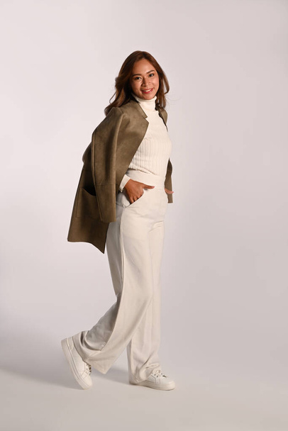 Ganztägiges Porträt der eleganten jungen Frau trendige Herbst-Outfits stehen auf weißem Hintergrund. - Foto, Bild
