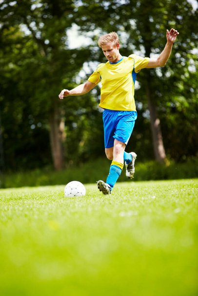 Practising his technique. a soccer player running up to kick the ball with gusto - Photo, image