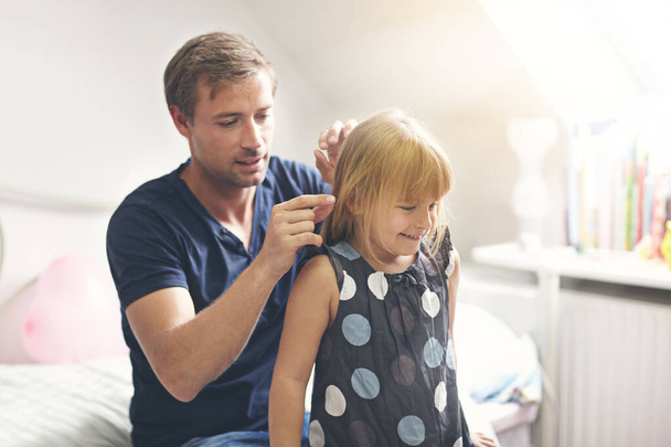 Doing his best as a single dad. a single dad helping his daughter with her hair - Foto, Imagem