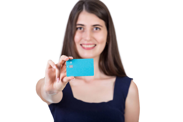 Happy young woman holding to camera a credit card. Close up portrait of a girl advertising a bank isolated on white background with copy space - Foto, Imagen