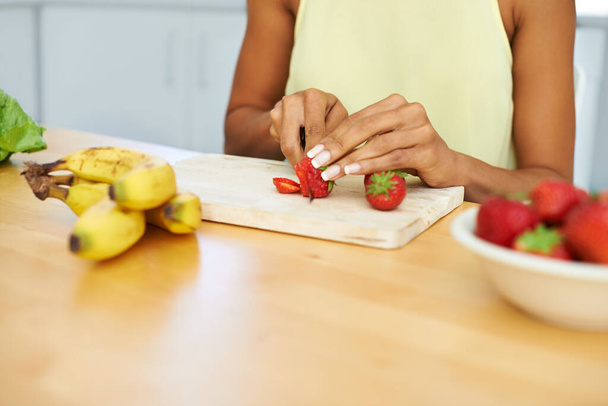 Fresh and fruity. a young woman slicing fruit in a kitchen - Fotoğraf, Görsel