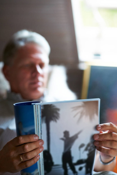 Rilassarsi con la sua rivista preferita. un anziano che legge una rivista nella sua camera da letto - Foto, immagini