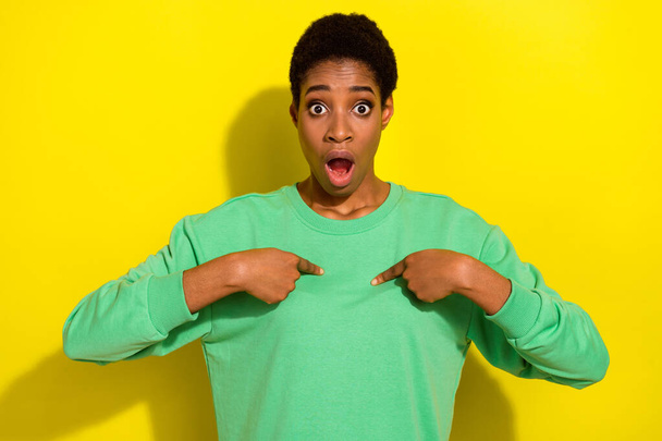 Photo of impressed funny androgynous human wear green pullover pointing fingers herself isolated yellow color background. - Foto, imagen