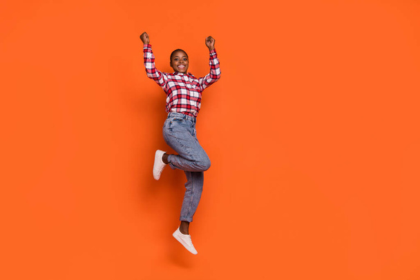 Full size portrait of overjoyed energetic person raise fists celebrate shout yes isolated on orange color background. - Фото, изображение