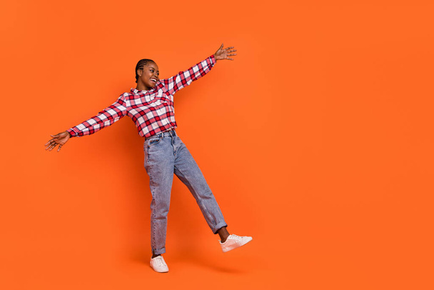 Full length portrait of satisfied adorable girl raise opened arms look empty space isolated on orange color background. - Fotografie, Obrázek
