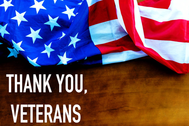 el texto gracias veteranos y una bandera de los Estados Unidos, sobre un fondo rústico de madera. - Foto, Imagen