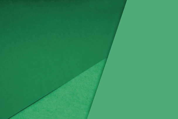 Dunkel und hell, einfache und strukturierte Schattierungen aus gelb-braunen grünen Papieren Hintergrundlinien, die sich zu einem Dreieck kreuzen - Foto, Bild